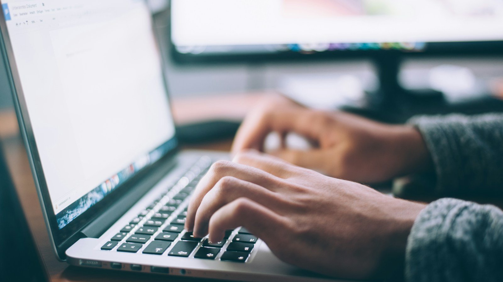 Hands using a laptop while reviewing website communications